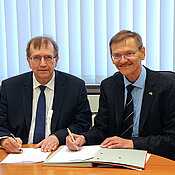 Präsident Alfred Forchel und Gerhard Bringmann unterzeichnen Vertrag.. (Foto: R. Emmerich)