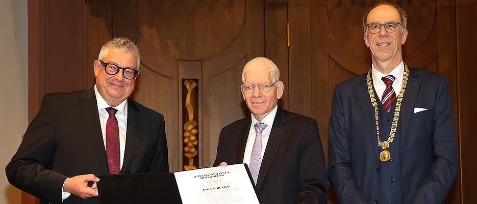 Josef Schuster (M.) mit der Ehrenpromotionsurkunde. Ihm gratulieren Matthias Remenyi (l.), Dekan der Katholisch-Theologischen Fakultät, und Paul Pauli, Präsident der Uni Würzburg.