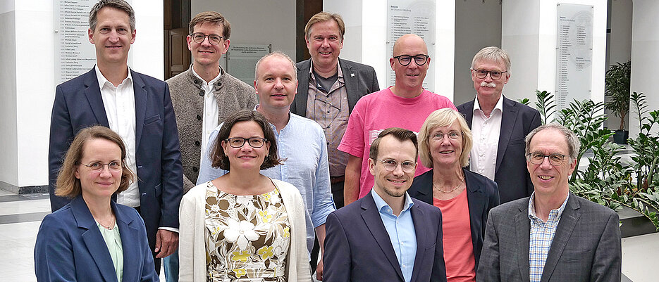 Teilnehmerinnen und Teilnehmer des Treffens an der JMU. Vordere Reihe von links: Vizepräsidentin Anja Schlömerkemper (JMU), Vizepräsidentin Kristin Weber (THWS), Präsident Jean Meyer (THWS), Präsident Paul Pauli (JMU). Mittlere Reihe von links: Vizepräsident Jan Schmitt (THWS), Vizepräsidentin Caroline Kisker (JMU). Hintere Reihe von links: Kanzler Stefan Hartmann (THWS), Vizepräsident Achim Förster (THWS), Vizepräsident Matthias Bode (JMU), Vizepräsident Martin Naumann (THWS) und Kanzler Uwe Klug (JMU).