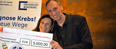 Alexander Meining überreichte nach der Lesung im Hofkeller der Würzburger Residenz den Spendencheck über 5.000 Euro an Gabriele Nelkenstock. 