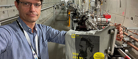 Alumnus Dr. Jan Grünert mit der Uni-Wü-Community-Tasche in den Photonentunneln des Europäischen Röntgenlasers.