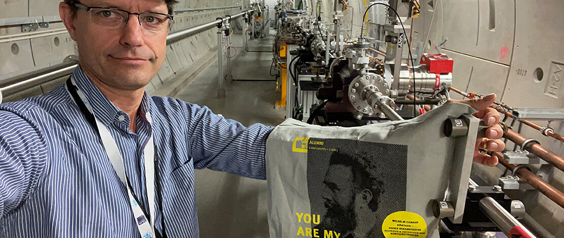 Alumnus Dr. Jan Grünert mit der Uni-Wü-Community-Tasche in den Photonentunneln des Europäischen Röntgenlasers.